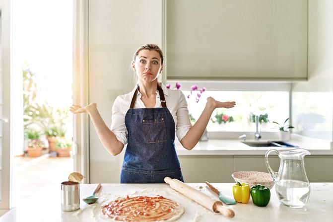 Femme perdue devant la préparation d'une pizza